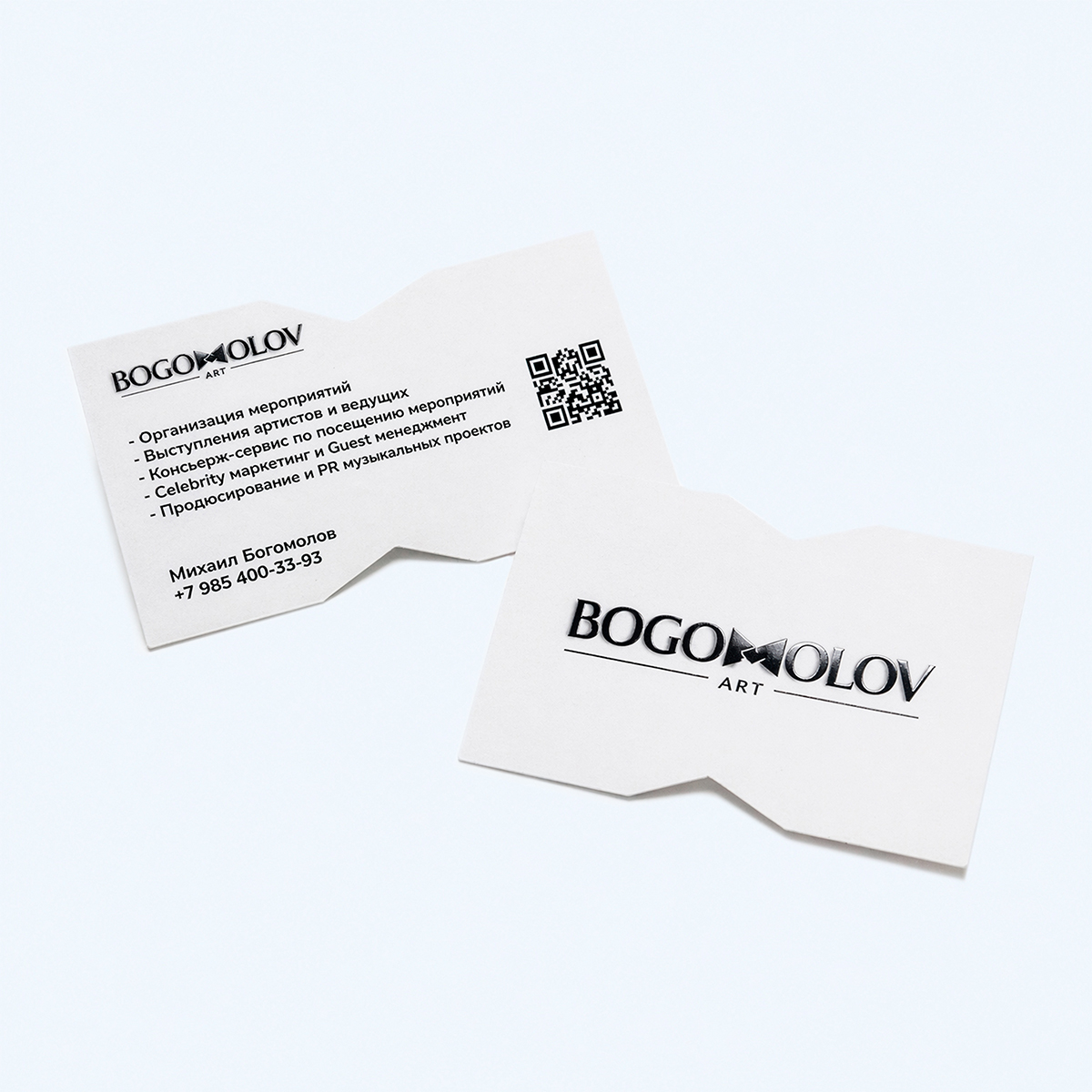 Фигурные визитки на белой бумаге с вырубкой, QR-кодом и черным тиснением логотипа